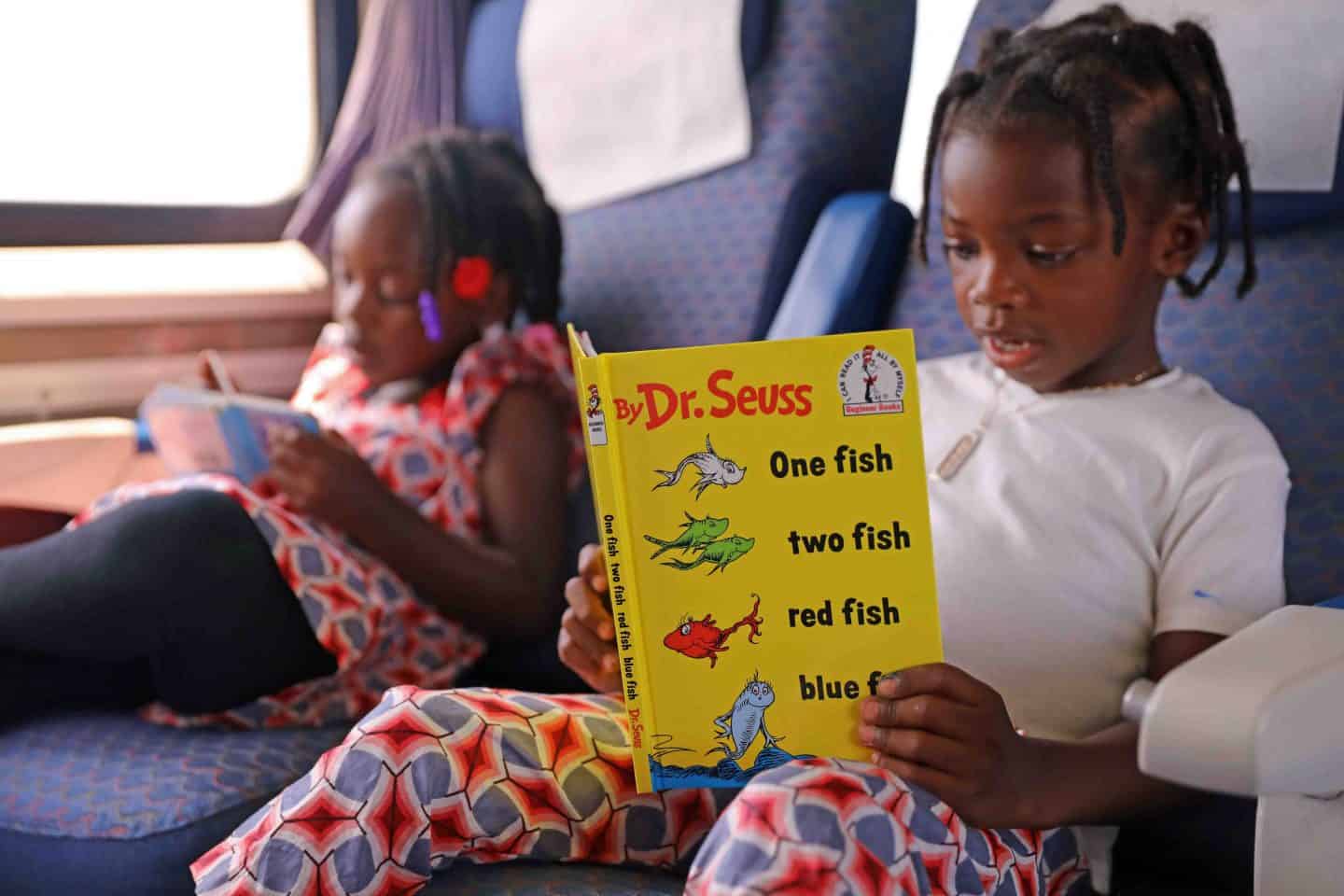 Two girls reading Dr. Suess books on the Los Angeles To San Diego Amtrak Train 