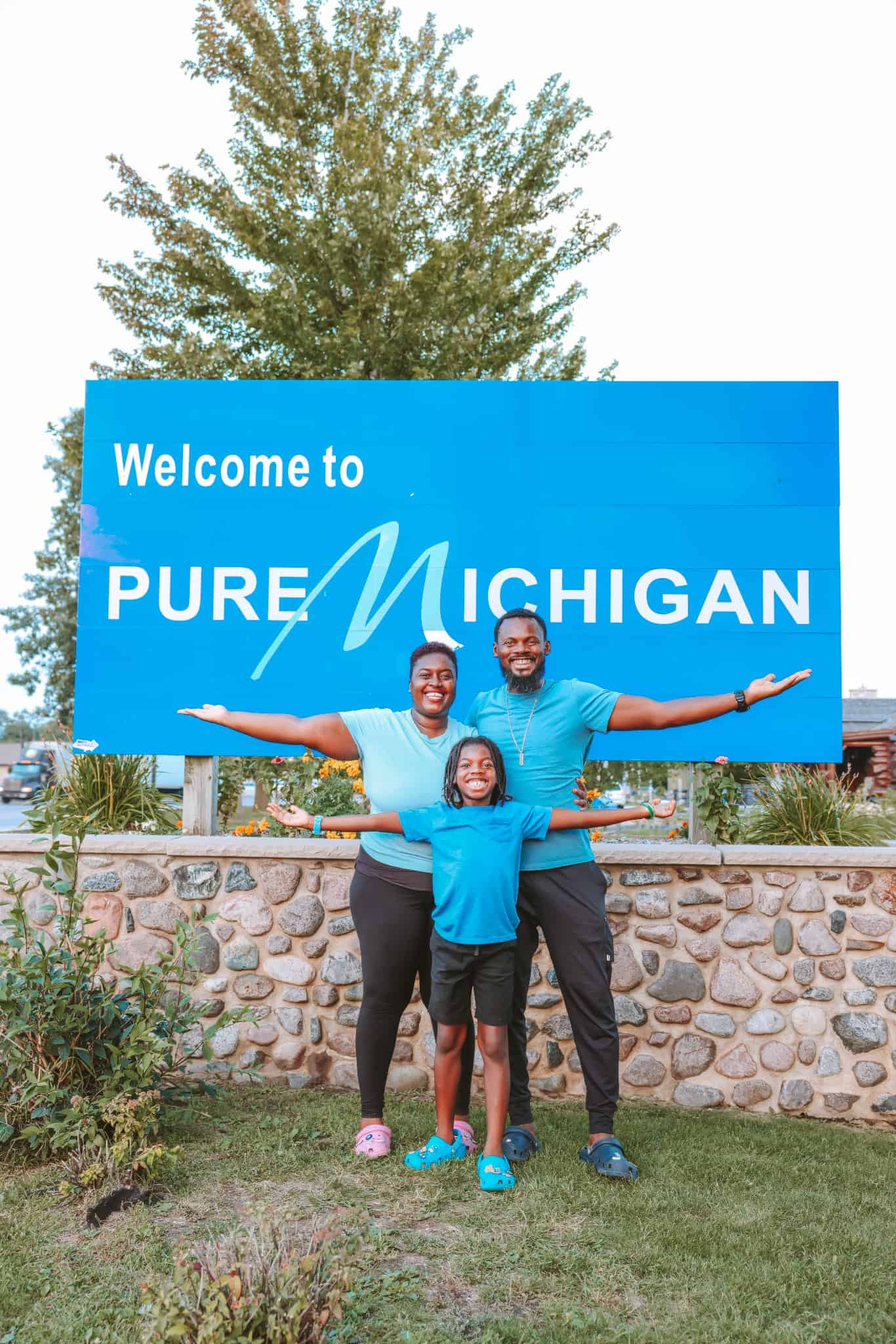 Family posing by Welcome to Michigan sign