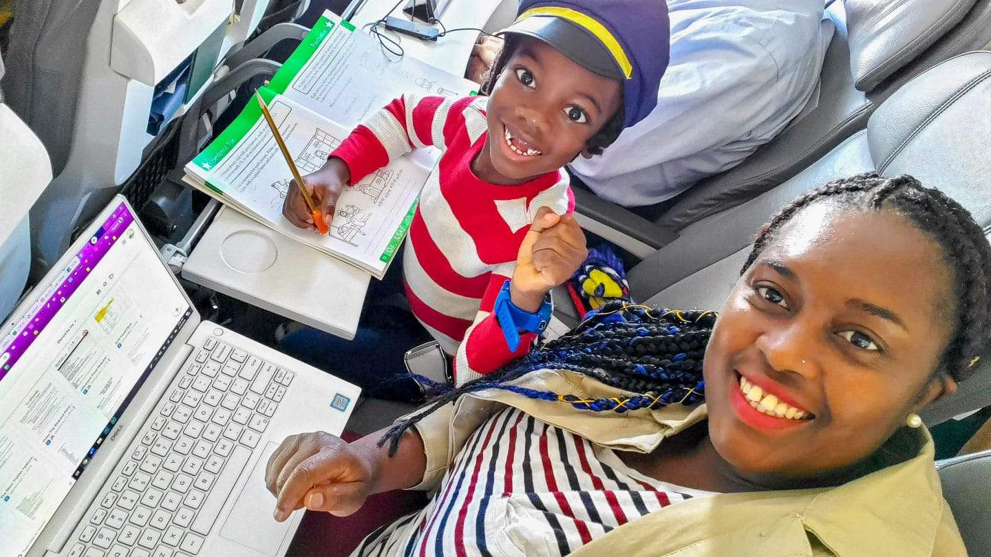 black kids do travel doing homework on an airlplane