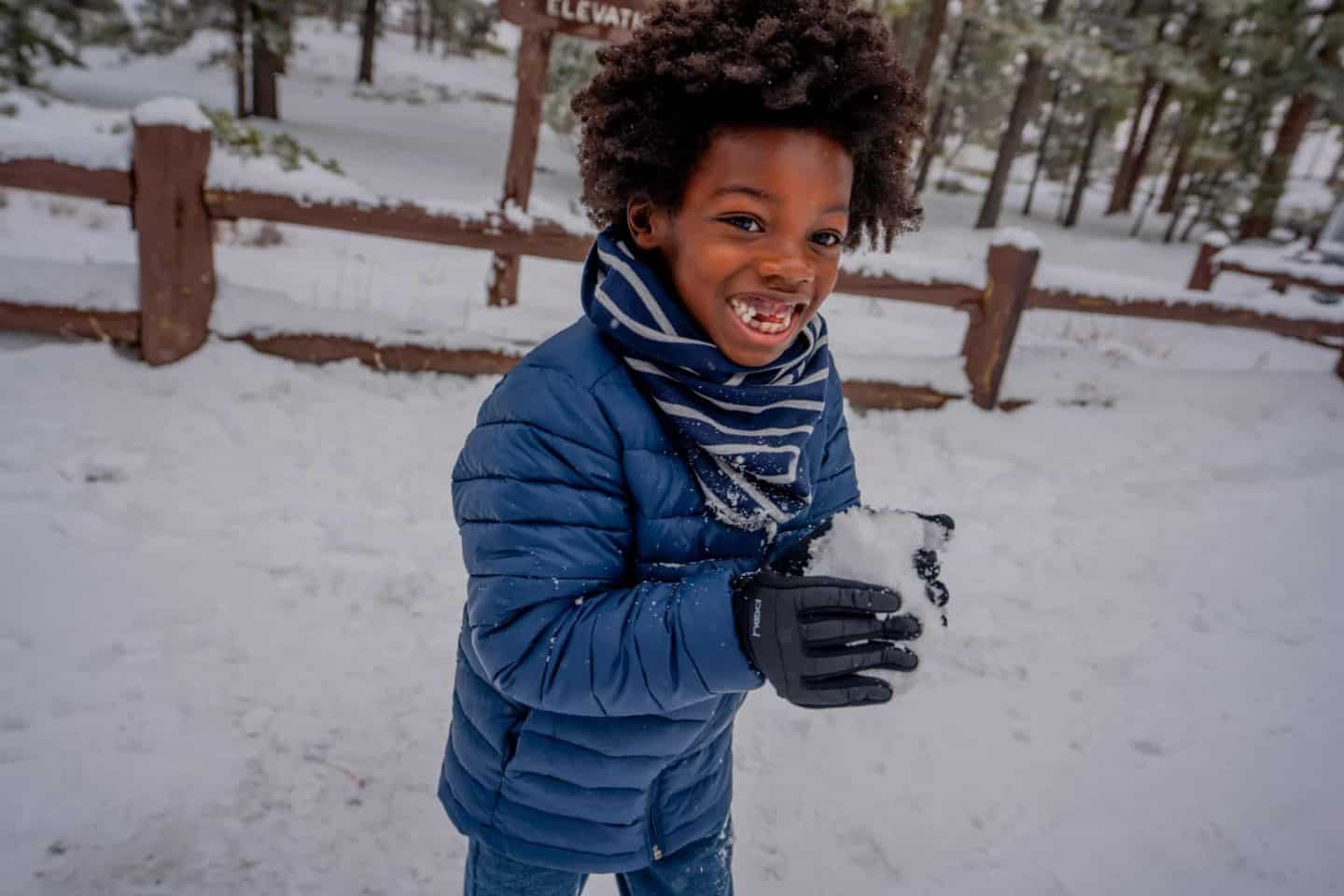 A boy making a snowball.