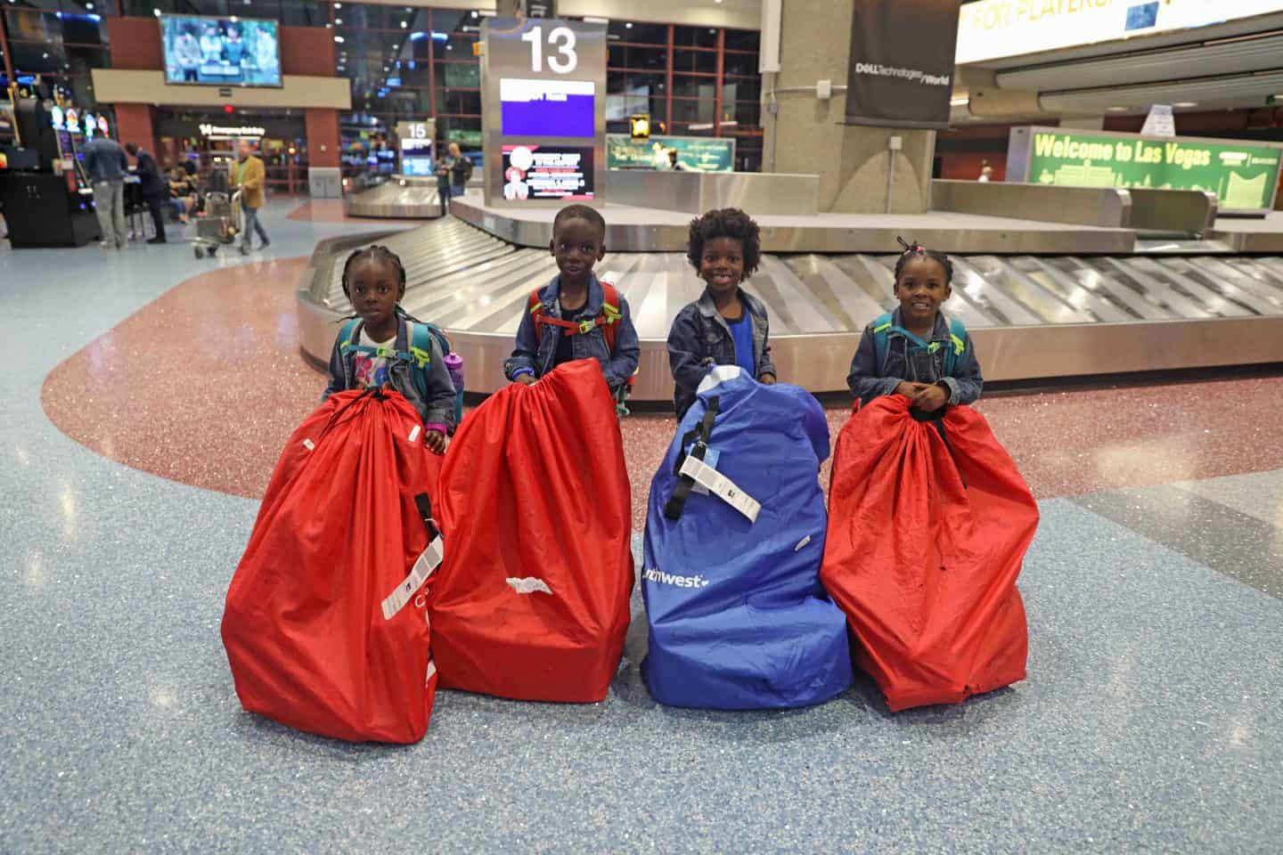 4 kids with their carseats in the baggage claim area of an airport - how to avoid extra fees when flying spirit airlines