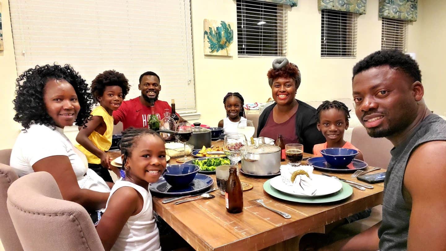 Black Family Travel how to celebrate easter without leaving your home black family having dinner at table meal time food